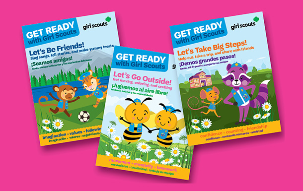 Three girl scout activity books on bright pink background