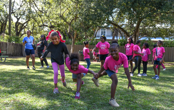 three girl scouts running and laughing outdoors at camp mahachee