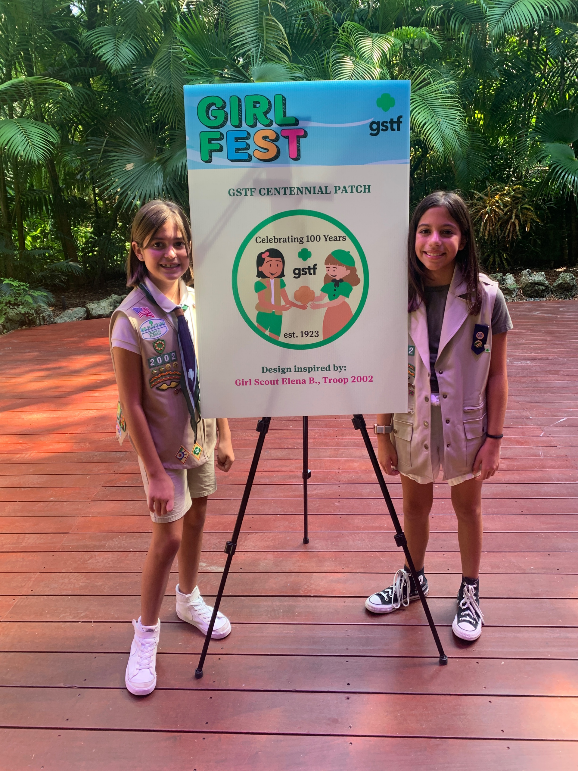 Girl Scout Elena (left) unveiling her winning design for the GSTF Centennial patch contest
