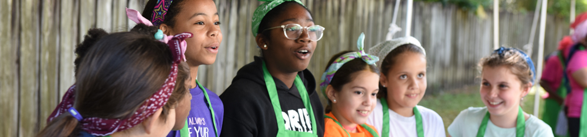  girl scout volunteer parent with young girl hiking outside at state park 