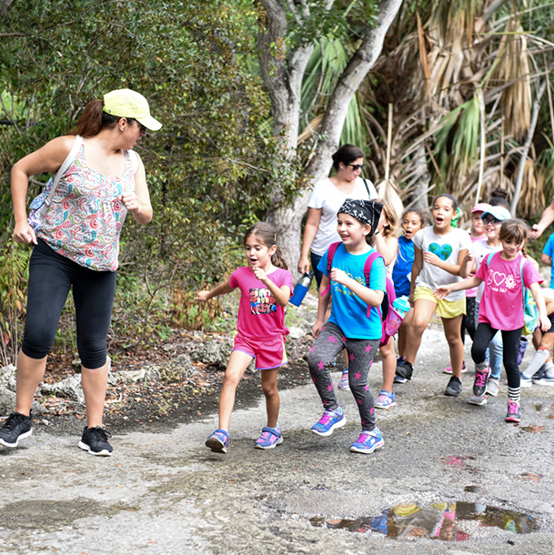 A troop leader  talking with two Girl Scouts