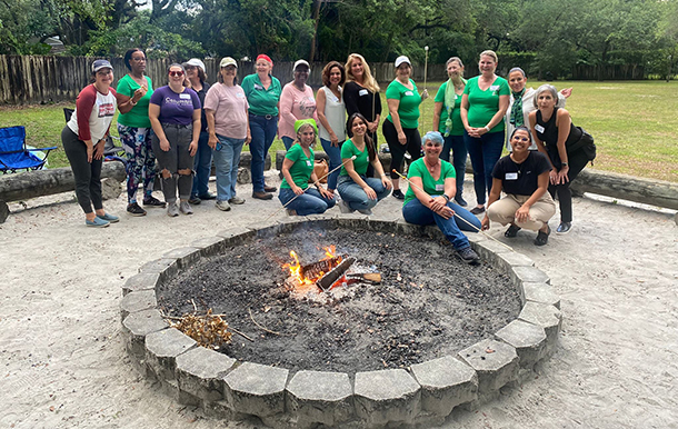 Adults roasting s'mores around the campfire