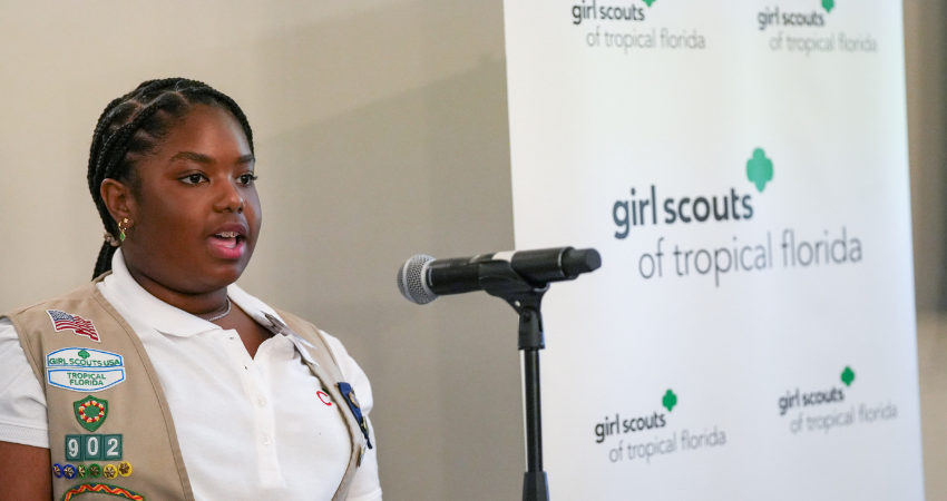 Confident black girl scout cadette speaking at microphone
