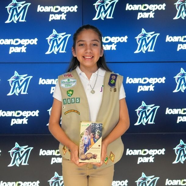 girl scout selling cookies with parent