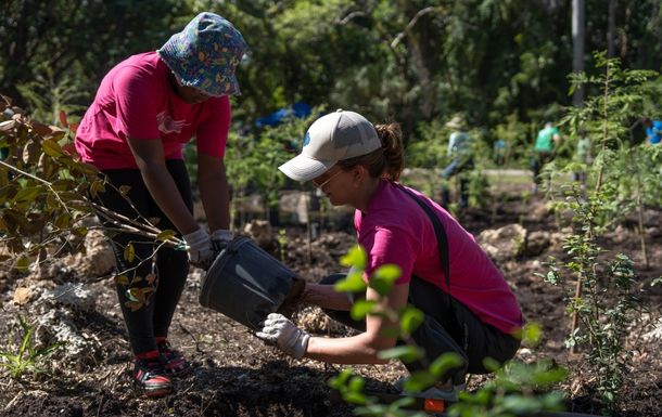 A mom at a tree planting event with girl scout 